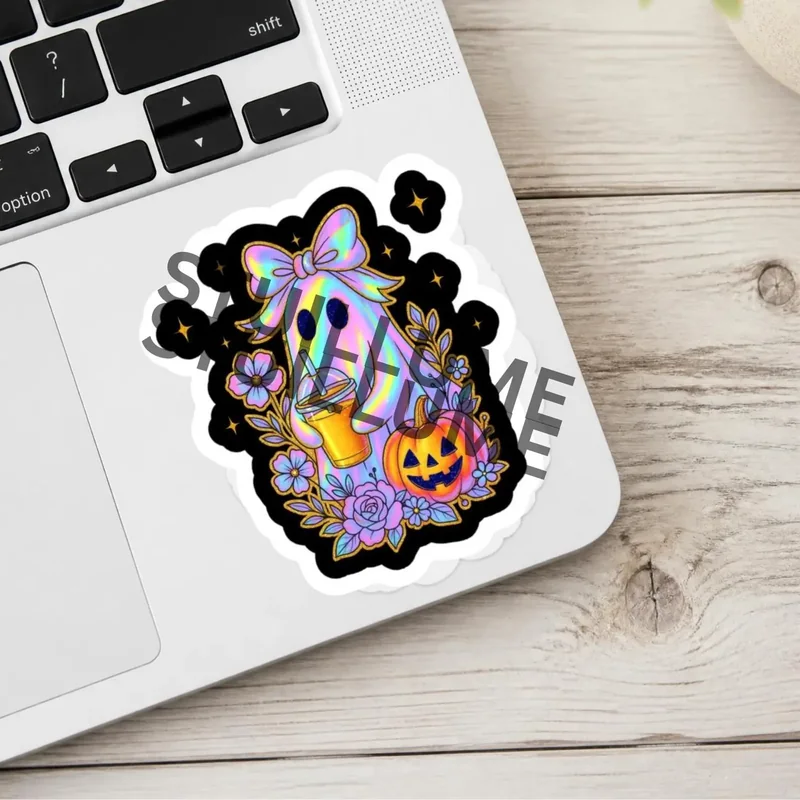 Iridescent pastel ghost wearing a colorful bow and holding an iced coffee, surrounded by flowers and a smiling Halloween pumpkin, displayed on a laptop.